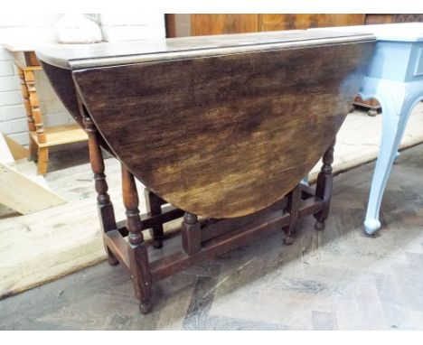 An oval oak gate legged table on turned legs, 39" wide
