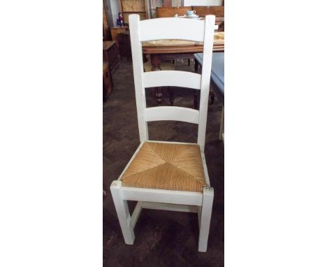 A set of four chunky, white painted, ladder back dining chairs with rush seats 