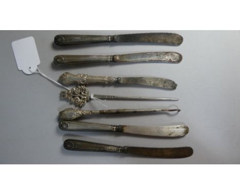 A Collection of Silver Handled Butter Knives and a White Metal Skewer, Finial and Dolphin Mount with Central Trident.  