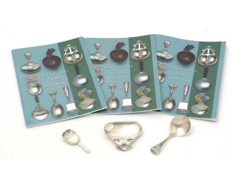 Two early 20th Century arts and crafts silver caddy spoons, together with a smaller silver caddy spoon, hallmarked Birmingham