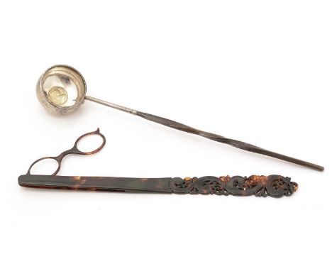 A pair of late 19th Century tortoiseshell lorgnettes, with fold-out lenses and a long, tapering handle, carved and pierced wi