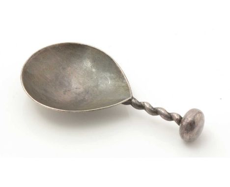 A George V silver arts and crafts caddy spoon, with a hammered bowl, a wire stem and a bun finial, by A.E. Jones, Birmingham 