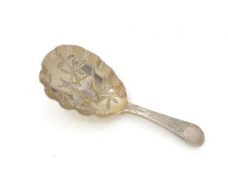 A Victorian silver-gilt caddy spoon, in the Japanese taste, chased with bamboo foliage and embossed in the bowl with a finch 