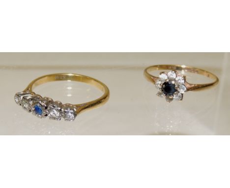 A 9ct gold dress ring of flower head design, set with a central blue stone with a surround of clear cubic zirconia's, ring si