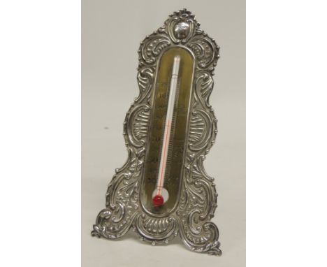 A Victorian silver mounted desk thermometer having an engraved brass scale and embossed silver surround with easel back,  Bir