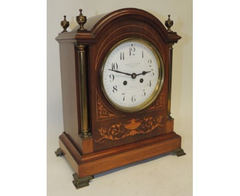 A late Victorian mantel clock the circular white enamel dial with black Arabic numerals and "Goldsmiths Company 112 Regent St