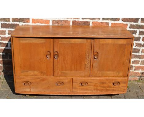 Ercol elm sideboard with interior cutlery drawer and three cupboard doors over two drawers raised on castors L 130 cm H 77 cm