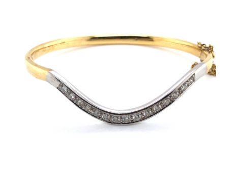 AN 18ct HALLMARKED WHITE AND YELLOW GOLD DIAMOND SET WISHBONE SHAPED HINGED BANGLE. THE WISHBONE WITH 15 GRAIN SET ROUND BRIL