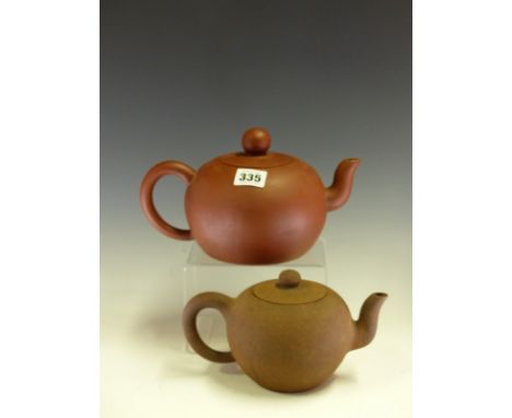 A CHINESE YIXING RED WARE TEA POT BEARING SEAL MARKS INSIDE THE COVER AND ON THE FOOT.   Dia 15cms. TOGETHER WITH ANOTHER OF 
