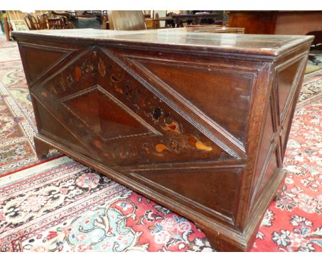 AN EARLY OAK COFFER, THE FRONT INLAID WITH A DIAMOND SHAPED BAND OF FLOWERS AND FOLIAGE ABOVE THE BRACKET FEET. W 140 x D 54 