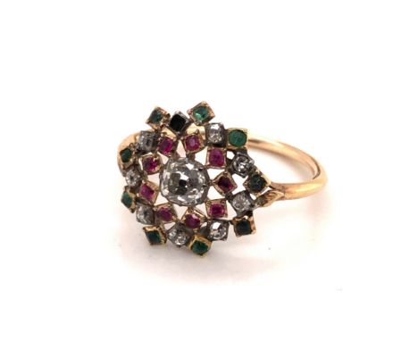 AN ANTIQUE OPEN WORK CLUSTER OLD CUT DIAMOND, RUBY AND EMERALD RING. UNHALLMARKED, ASSESSED AS GOLD WITH A SILVER HEAD. FINGE