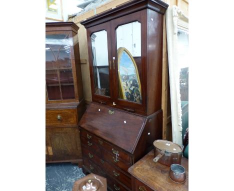 A GEORGE III MAHOGANY BUREAU BOOK CASE WITH A CAVETTO CORNICE ABOVE MIRRORED DOORS AND TWO CANDLE SLIDES, THE FALL ABOVE TWO 