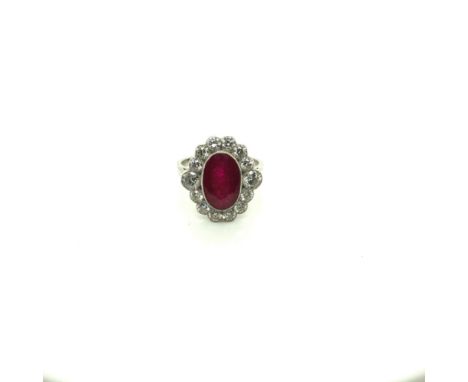 A RUBY AND DIAMOND EDWARDIAN STYLE OVAL CLUSTER RING. UNHALLMARKED, ASSESSED AS PLATINUM. FINGER SIZE N. WEIGHT 6.41grms.