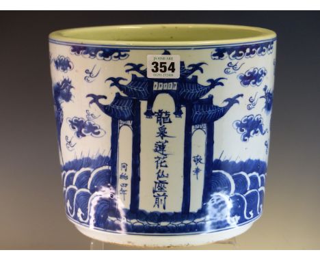 A CHINESE BLUE AND WHITE PLANTER, THE TAPERING CYLINDRICAL EXTERIOR PAINTED WITH TWO PHOENIX OVER WAVES FACING A TEMPLE INSCR