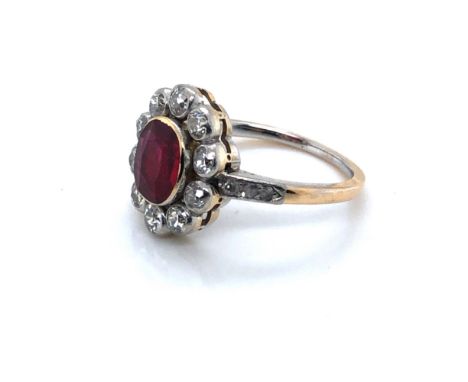 AN ANTIQUE RUBY AND DIAMOND OVAL CLUSTER RING. THE OVAL RUBY SURROUNDED BY TEN OLD CUT DIAMONDS UPON DIAMOND SET SHOULDERS, U