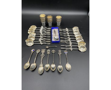 Eighteen white metal spoons marked WH to underside; together with twelve silver plate shot beakers and a quantity of silver p