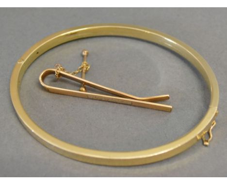 A 9ct. Gold Bangle together with a 9ct. Gold Tie Clip, 12.4 gms