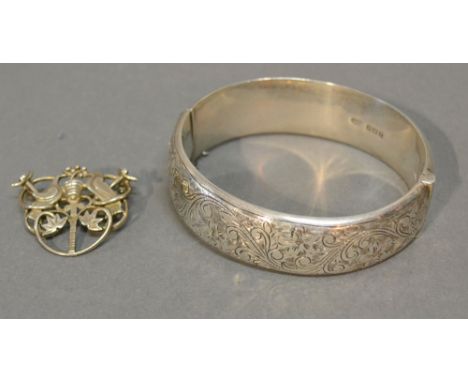 A Birmingham Silver Bangle with engraved decoration together with a white metal brooch with pierced decoration depicting two 