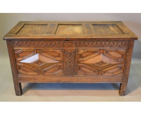 A George III Oak Coffer, the hinged top above a moulded double panel front flanked by stiles, 122 cms wide, 54 cms deep, 67 c
