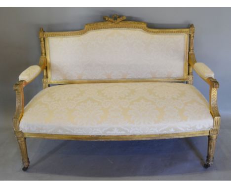 A Late 19th Early 20th Century French Gilded Salon Sofa with an upholstered back and seat with scroll arms raised upon turned