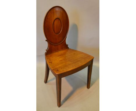 A Regency Mahogany Hall Chair, the oval moulded back above a panel seat raised upon square tapering legs