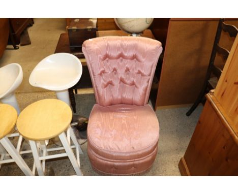 A pink upholstered button back bedroom chair 