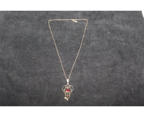 An Edwardian 9ct gold and garnet set pendant and a rolled gold chain