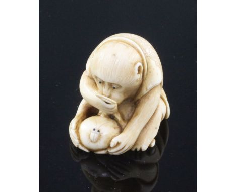 A Japanese ivory netsuke of a monkey viewing an insect through a magnifying glass, signed Masatami, Edo period, the monkey gr