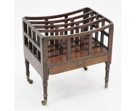 A George III mahogany canterbury, with four divisions over a base drawer, on ring turned tapered legs, fitted brass castors, 