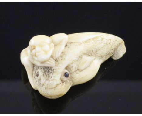 A Japanese ivory netsuke of a man riding an earthquake fish, Edo period, the fish with horn inset eyes, unsigned, 4.7cm