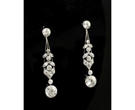 A good pair of 1920's platinum and diamond drop earrings, with tapering stems and millegrain set foliate motifs, each round c