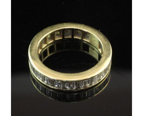 An 18ct gold and diamond full eternity ring, with channel set baguette cut diamonds, size K.