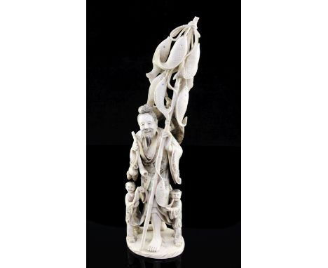 A large Chinese ivory group of a fisherman and two children, first half 20th century, the fisherman holding a pipe and a bamb