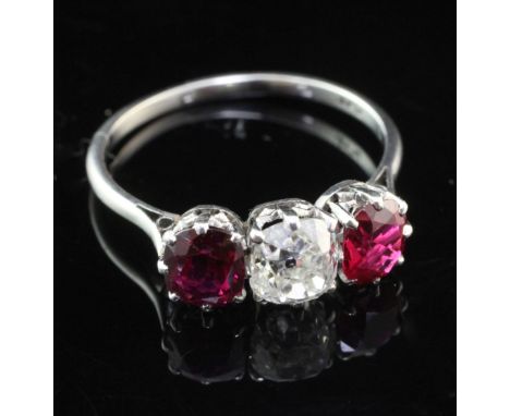 An early 20th century platinum and three stone ruby and diamond ring, the cushion cut diamond flanked by two similar cut rubi