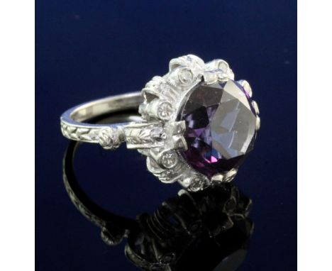 A modern white gold, synthetic colour change corundum and diamond cluster dress ring, of circular form, size P.