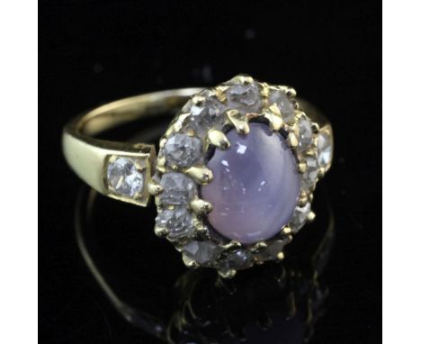 A gold, star sapphire and diamond oval cluster ring, set with old mine cut diamonds and diamond set shoulders, size K.