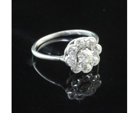 A white gold and diamond cluster ring, of flower head design and set with nine round cut stones, size O.