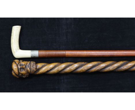 An early 20th century bone handled sword stick, with blued steel floral decoration, together with a carved ropetwist walking 