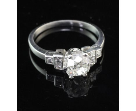 A white gold and single stone cushion cut diamond ring with diamond set shoulders, the central stone weighing approximately 1