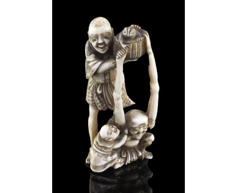 A Japanese ivory okimono of Ashinaga and Tenaga, Meiji period, the two figures holding aloft a basket containing a toad with 