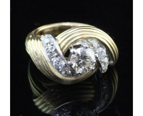 A 1940's French 18ct gold and diamond dress ring, of reeded scrolling design, the central diamond weighing approximately 1.00