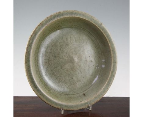 A Chinese Longquan celadon dish, 15th century, the well incised with a flower and foliage, burnt brown unglazed patch to base
