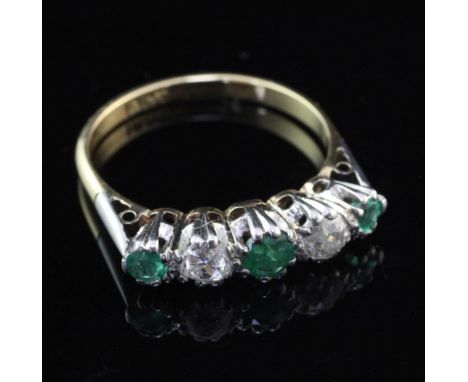 An early to mid 20th century 18ct gold, emerald and diamond ring graduated five stone half hoop ring, set with old round cut 