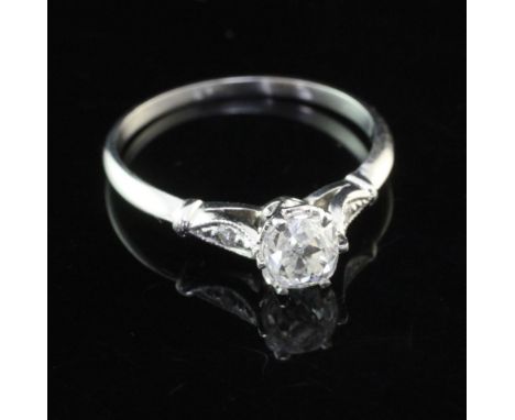 A platinum and single stone cushion cut diamond ring with diamond set shoulders, the central stone weighing approximately 0.6