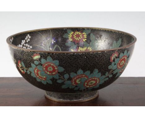 A Chinese cloisonne enamel bowl, late 19th century, decorated with prunus and flower blossoms on a black key fret ground, the