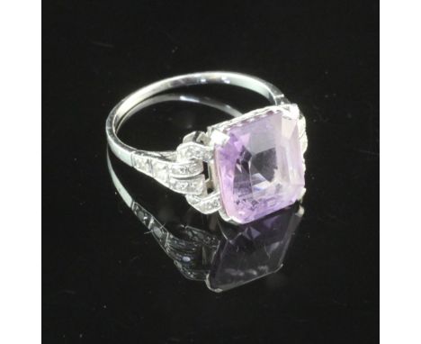 A 1920's/1930's platinum, amethyst and diamond ring, with emerald cut amethyst and eight cut diamond set shoulders, size O.