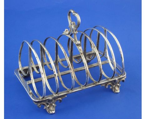 A Victorian silver seven bar toast rack, by The Barnards, with shaped ring handle, on scroll feet, London, 1841 (a.f.), lengt