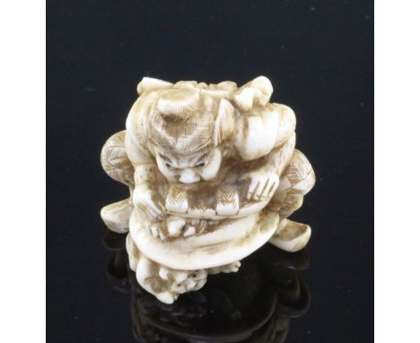 A Japanese walrus ivory netsuke of Shoki crushing two oni, signed Gyokuzan, Meiji period, 3.8cm