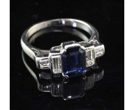 An early 20th century 18ct white gold, sapphire and diamond ring, the central emerald cut sapphire weighing approximately 1.6