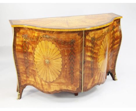 A George III style satinwood and marquetry serpentine commode, in the style of John Cobb, the top inlaid with a demi-patera a